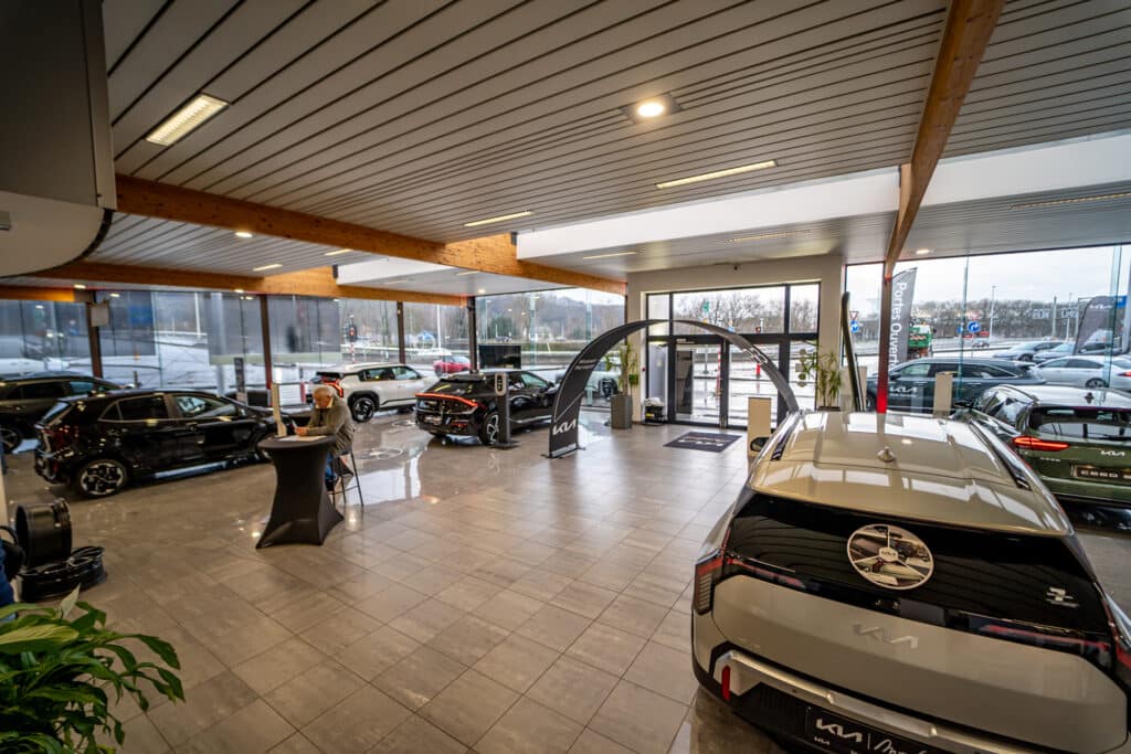 Vue d'ensemble du showroom du garage Incar Motor à Angleur, présentant une sélection de véhicules Kia neufs et d'occasion.